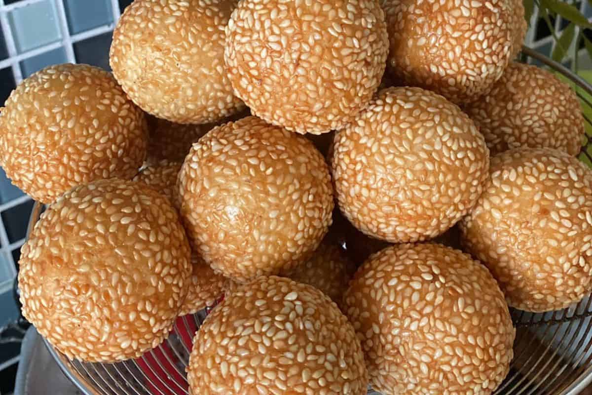 Kuih bom bersalut bijan berwarna keemasan di atas pinggan