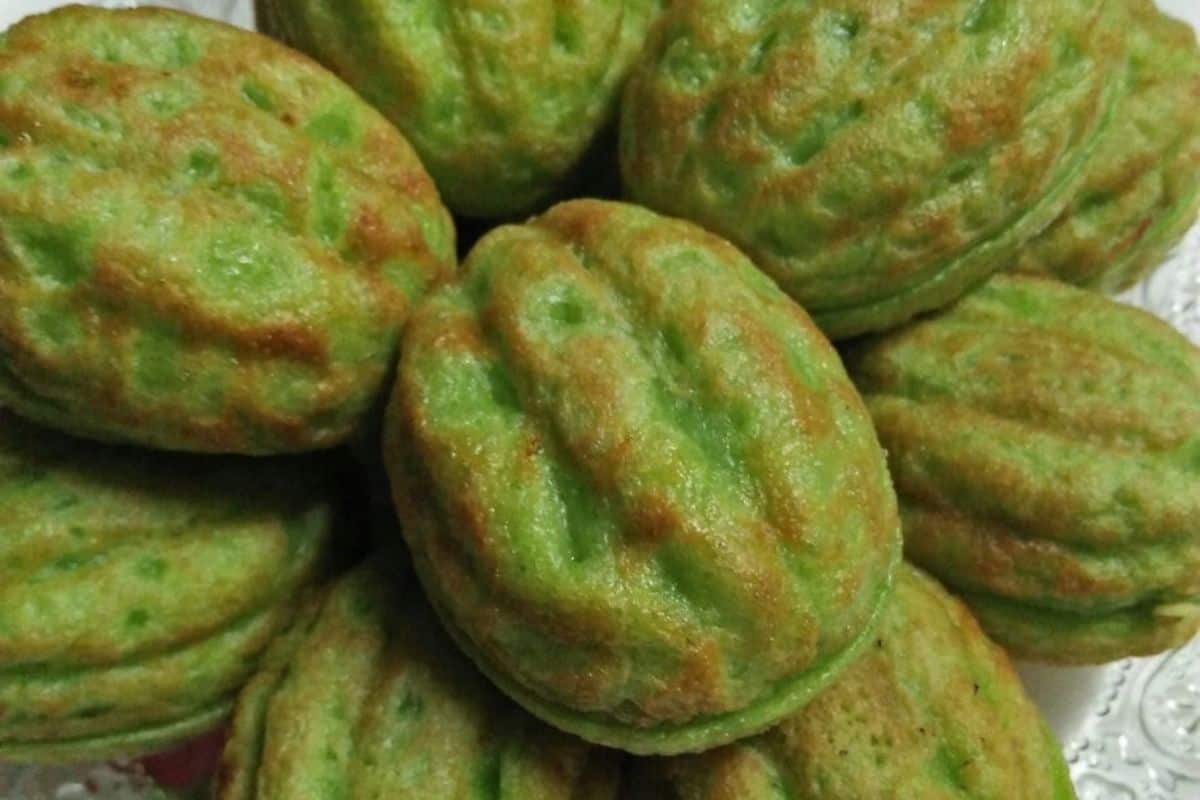 Kuih cara manis berwarna hijau dengan gula Melaka di tengah dalam acuan kuih cara