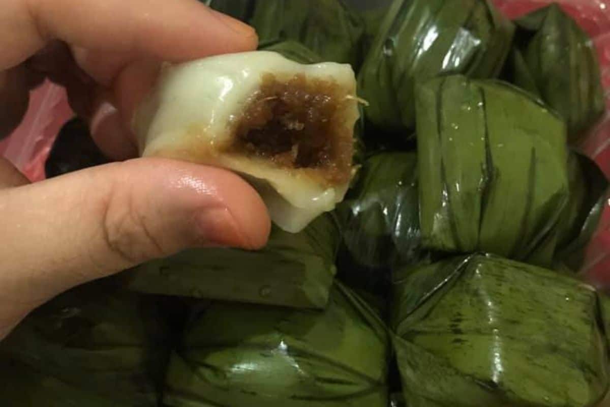 Kuih koci berbungkus daun pisang berbentuk kon disusun rapat di atas dulang